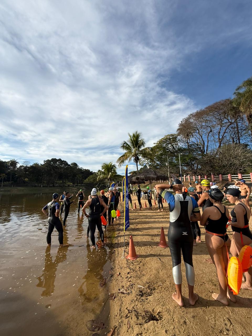 Atletas reunidos na margem da lagoa
