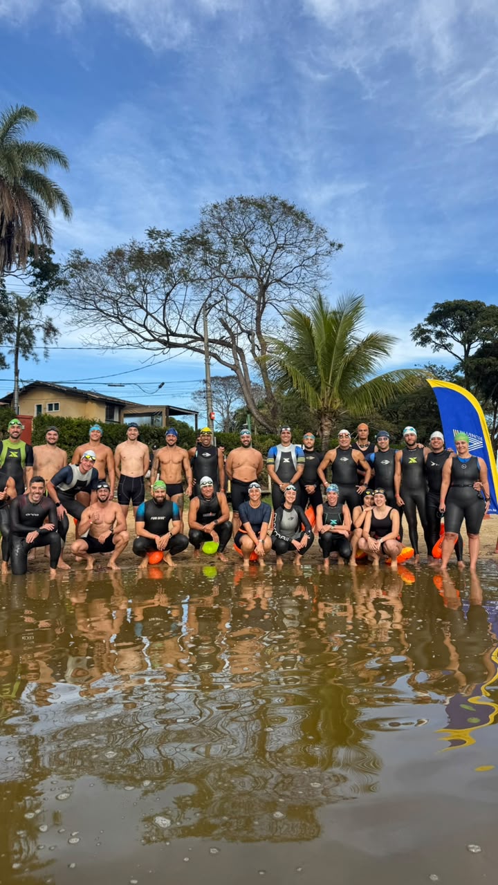 Grupo de atletas reunidos na margem da lagoa